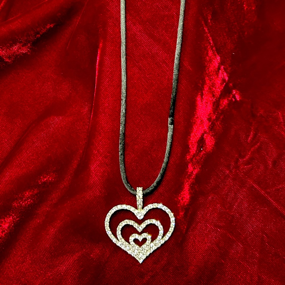 Nolan Miller Silvertone crystal triple heart pendant on black cord